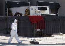 A member of a forensic team walks in front of a truck in which more than 70 bodies were found, at a customs building with refrigeration facilities in the village of Nickelsdorf, Austria, August 29, 2015. PHOTO BY REUTERS/Heinz-Peter Bader