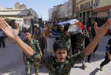 Mourners carry the coffin of Salah al-Wa'ili, a fighter from the Iraqi Shi'ite group Asa'ib Ahl al-Haq, during his funeral in Najaf