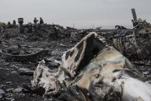 People talk near the remains of fuselage of the downed Malaysia Airlines flight MH17, near the village of Hrabove (Grabovo) in Donetsk region, eastern Ukraine September 9, 2014. PHOTO BY REUTERS/Marko Djurica