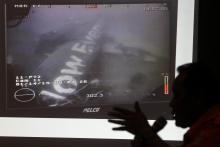 Head of the National Search and Rescue Agency Fransiskus Bambang Soelistyo is seen with an image believed to be of the fuselage of AirAsia Flight QZ8501, taken by an underwater ROV provided by the Singaporean Navy, during a news conference in Jakarta, January 14, 2015. PHOTO BY REUTERS/Pius Erlangga