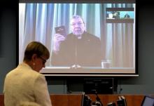 Senior Counsel Assisting Gail Furness stands in front of a screen displaying Australian Cardinal George Pell as he holds a bible while appearing via video link from a hotel in Rome, Italy to testify at the Australia's Royal Commission into Institutional Response to Child Sexual Abuse in Sydney, Australia, February 29, 2016. PHOTO BY REUTERS/Jeremy Piper-Oculi