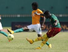 Ivory Coast's Gervinho (L) fights for the ball with Ambroise Oyongo of Cameroon during their African Nations Cup qualifying soccer match at the Felix Houphouet Boigny stadium in Abidjan, November 19, 2014. PHOTO BY REUTERS/Luc Gnago