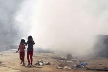 Girls walk near garbage on fire, piled up along a street in the Chiah area in Beirut, Lebanon, August 27, 2015. PHOTO BY REUTERS/Aziz Taher