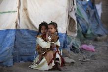 A girl holds her sister outside their tent at a camp for people displaced by recent fighting between government forces and Shi'ite rebels in the northwestern Yemeni city of Saada, December 13, 2011. PHOTO BY REUTERS/Khaled Abdullah