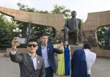 Graduates pose and take pictures in front of a statue of Kazakh President Nursultan Nazarbayev at the First President's Park in Almaty, Kazakhstan, July 3, 2015. PHOTO BY REUTERS/Shamil Zhumatov