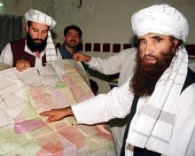 Jalaluddin Haqqani (R), the Taliban's Minister for Tribal Affairs, points to a map of Afghanistan during a visit to Islamabad, Pakistan, October 19, 2001 while his son Naziruddin (L) looks on. PHOTO BY REUTERS