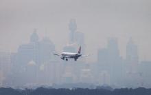 An Australian commercial aircraft prepares to land in the haze at Sydney's International Airport, July 15, 2014. PHOTO BY REUTERS/Jason Reed