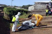 Health workers remove the body of a woman who died from the Ebola virus in the Aberdeen district of Freetown, Sierra Leone, October 14, 2014. PHOTO BY REUTERS/Josephus Olu-Mammah