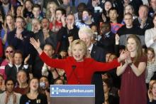 Former U.S. President Bill Clinton (rear) applauds his wife, Democratic U.S. presidential candidate Hillary Clinton, as they appear with their daughter Chelsea (R) at Mrs. Clinton's caucus night rally in Des Moines, Iowa, February 1, 2016. PHOTO BY REUTERS/Adrees Latif