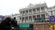 A cameraman films outside Palais Coburg hotel where nuclear talks are taking place in Vienna