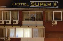 People look from the window of a quarantined hotel in Skopje