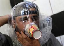 Hudhayfa al-Shahad tries an improvised gas mask in Idlib, Syria, September 3, 2018. PHOTO BY REUTERS/Khalil Ashawi