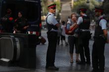 Pilar Revilla, 75, gets emotional after hugging a Catalan Mossos d'Esquadra officer after visiting an impromptu memorial where a van crashed into pedestrians at Las Ramblas in Barcelona, Spain, August 20, 2017. PHOTO BY REUTERS/Susana Vera
