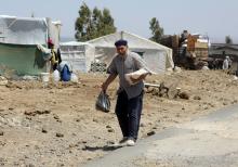 Internally displaced man holds a stack of bread near the Israeli-occupied Golan Heights in Quneitra, Syria July 11, 2018. PHOTO BY REUTERS/Alaa Al-Faqir