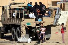 Displaced Iraqi people who fled from clashes ride in a military truck during a battle between Iraqi forces and Islamic state militants in western Mosul, Iraq, May 17, 2017. PHOTO BY REUTERS/Alaa Al-Marjani