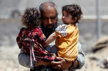 A girl looks out from the arms of a displaced resident, who fled home due to the ongoing fighting between the Iraqi forces and Islamic State militants near the Old City in western Mosul, Iraq, June 13, 2017. PHOTO BY REUTERS/Erik De Castro