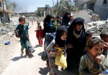 Displaced civilians walk towards the Iraqi Army positions after fleeing their homes due to clashes in the Shifa neighbourhood in western Mosul, Iraq, June 15 2017. PHOTO BY REUTERS/Erik De Castro