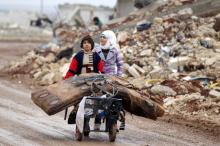 Samah, 11, and her brother, Ibrahim, transport their salvaged belongings from their damaged house in Doudyan village in northern Aleppo Governorate, Syria, January 2, 2017. PHOTO BY REUTERS/Khalil Ashawi