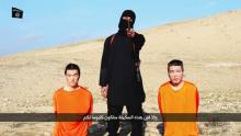 A masked person holding a knife speaks as he stands in between two kneeling men in this still image taken from an online video released by the militant Islamic State group, January 20, 2015. PHOTO BY REUTERS/Social media website via Reuters TV
