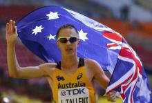 Jared Tallent of Australia holds his national flag as he celebrates finishing third place in the men's 50 km race walk final during the IAAF World Athletics Championships at the Luzhniki stadium in Moscow, August 14, 2013. PHOTO BY REUTERS/Denis Balibouse