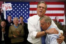 Jeb Bush embraces Lindsey Graham after Graham introduced him at a town hall during a campaign stop at Woodbury School in Salem, February 7, 2016. PHOTO BY REUTERS/Adrees Latif