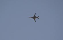 A jet from the U.S.-led coalition flies in the sky over the Syrian town of Kobani as seen from a hill in Tal-Hajeb village that overlooks Kobani