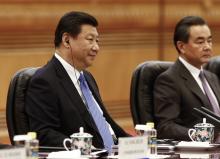 Chinese President Xi Jinping (L) listens with an earpiece as Chinese Foreign Minister Wang Yi (R) looks on during a meeting with Argentinian President Cristina Fernandez de Kirchner (not pictured) at the Great Hall of the People in Beijing, February 4, 2015. PHOTO BY REUTERS/Rolex Dela Pena