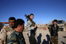 U.S. volunteer John Cole (C), 23, carries his assault rifle at a checkpoint in Makhmour, Iraq, April 17, 2016. PHOTO BY REUTERS/Ahmed Jadallah