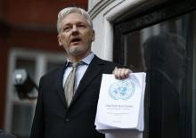 WikiLeaks founder Julian Assange holds a copy of a U.N. ruling as he makes a speech from the balcony of the Ecuadorian Embassy, in central London, Britain, February 5, 2016. PHOTO BY REUTERS/Peter Nicholls