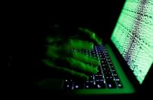 A man types on a computer keyboard in front of the displayed cyber code in this illustration picture taken on March 1, 2017. PHOTO BY REUTERS/Kacper Pempel/Illustration