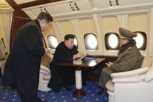 North Korean leader Kim Jong Un (C) talks with officials onboard his personal plane in this undated photo released by North Korea's Korean Central News Agency (KCNA) in Pyongyang, February 15, 2015. PHOTO BY REUTERS/KCNA