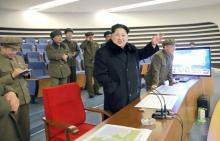 North Korean leader Kim Jong Un (C) reacts as he watches a long range rocket launch in North Korea, February 7, 2016. PHOTO BY REUTERS/Kyodo