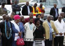 AbaThembu King Buyelekhaya Dalindyebo (3rd L) looks on with some members of his family as former South African President Nelson Mandela's flag-draped coffin arrives at the Mthatha airport, in the Eastern Cape province, 900 km (559 miles) south of Johannesburg for a funeral, December 14, 2013. PHOTO BY REUTERS/Siphiwe Sibeko
