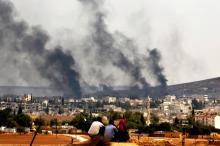 Kurdish refugees from Kobani watch as thick smoke covers the Syrian town of Kobani during fighting between Islamic State and Kurdish Peshmerga forces, as seen from the Mursitpinar crossing on the Turkish-Syrian border in Sanliurfa province, October 26, 2014. PHOTO BY REUTERS/Yannis Behrakis