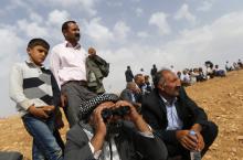 Turkish Kurds watch the Syrian town of Kobani from near the Mursitpinar border crossing, on the Turkish-Syrian border in the southeastern town of Suruc in Sanliurfa province
