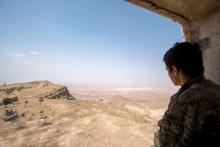 A Kurdish People's Protection Units (YPG) fighter stands on a lookout point on Abd al-Aziz mountain, Hasaka province, May 20, 2015. PHOTO BY REUTERS/Rodi Said
