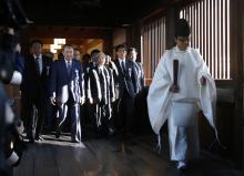 A group of lawmakers including Japan's ruling Liberal Democratic Party (LDP) lawmaker Hidehisa Otsuji (3rd L) are led by a Shinto priest as they visit Yasukuni Shrine in Tokyo