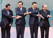 Cambodia's Prime Minister Hun Sen (L-R), Thailand's Prime Minister Prayuth Chan-ocha, China's Premier Li Keqiang and Myanmar's President Thein Sein join hands before posing for photographers during the opening ceremony of the 5th Greater Mekong Subregion (GMS) Summit at a hotel in Bangkok, December 20, 2014. PHOTO BY REUTERS/Chaiwat Subprasom