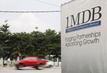 Traffic passes a 1Malaysia Development Berhad (1MDB) billboard at the Tun Razak Exchange development in Kuala Lumpur, Malaysia, July 6, 2015. PHOTO BY REUTERS/Olivia Harris