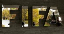 Journalists are reflected in FIFA's logo as they wait during an extraordinary meeting of the FIFA Executive Committee in front of FIFA's headquarters in Zurich, Switzerland, October 20, 2015. PHOTO BY REUTERS/Arnd Wiegmann