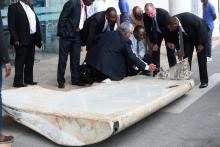 Ministry of Transport Malaysian Senior Accident investigator Aslam Basha Kham (C) talks to other officials inspecting a wing suspected to be a part of missing Malaysia Airlines jet MH370 discovered on the island of Pemba, off the coast of Tanzania, in Dar es Salaam, Tanzania, July 15, 2016. PHOTO BY REUTERS/Stringer