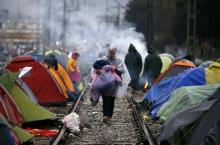 A migrant, who is waiting to cross the Greek-Macedonian border, carries his belongings at a makeshift camp near the village of Idomeni, Greece, March 9, 2016. PHOTO BY REUTERS/Stoyan Nenov