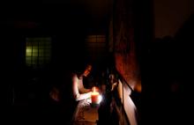 Maha Ragaay prays and lights a candle in front of a wooden figure of Jesus on a cross in her home at the Cairo suburb of Maadi, Egypt, April 14, 2017. PHOTO BY REUTERS/Amr Abdallah Dalsh
