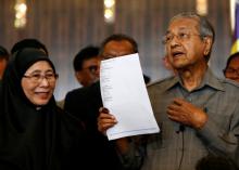 Mahathir Mohamad holds up a document with the signatures of alliance party leaders naming him as the prime minister as he stands with Wan Azizah, wife of jailed opposition figure Anwar Ibrahim, during a news conference following the general election in Petaling Jaya, Malaysia, May 10, 2018. PHOTO BY REUTERS/Lai Seng Sin