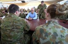 Australian Prime Minister Malcolm Turnbull (C) talks with Australian troops during breakfast at Camp Baird, located in the Middle East, during his visit to Iraq, January 16, 2016. PHOTO BY REUTERS/Alex Ellinghausen