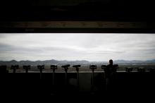 A man stands near binoculars as he tries to see North Korea's propaganda village of Gijungdong at the Dora observatory near the demilitarised zone separating the two Koreas, in Paju, South Korea, April 24, 2018. PHOTO BY REUTERS/Kim Hong-Ji