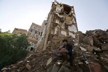 A man sits at a site which the Houthi-led authorities say was hit by a Saudi-led air strike at the old quarter of Yemen's capital Sanaa, August 9, 2015. PHOTO BY REUTERS/Khaled Abdullah