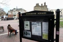 A man sits on a bench next to a sign on Windrush Square in the Brixton district of London, Britain, April 16, 2018. PHOTO BY REUTERS/Simon Dawson