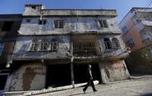 A man walks past a building which was damaged during the security operations and clashes between Turkish security forces and Kurdish militants, in the southeastern town of Silvan in Diyarbakir province, Turkey, December 7, 2015. PHOTO BY REUTERS/Murad Sezer