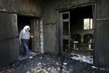 A Palestinian man inspects a house that was badly damaged from a suspected attack by Jewish extremists on two houses at Kafr Duma village near the West Bank city of Nablus, in this July 31, 2015 file picture. PHOTO BY REUTERS/Abed Omar Qusini